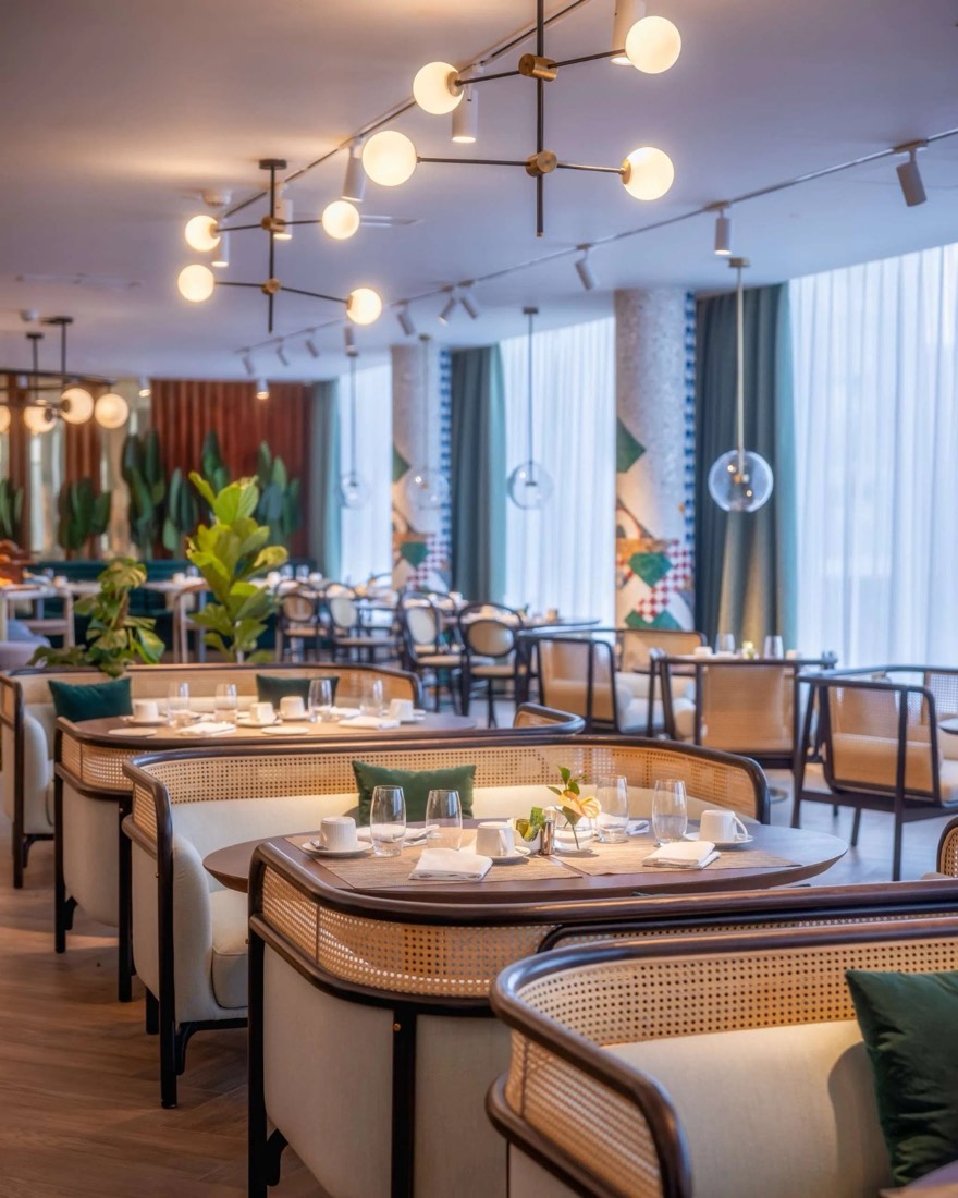 Restaurant dining room with cane booths and globe lighting at Gem Forest
