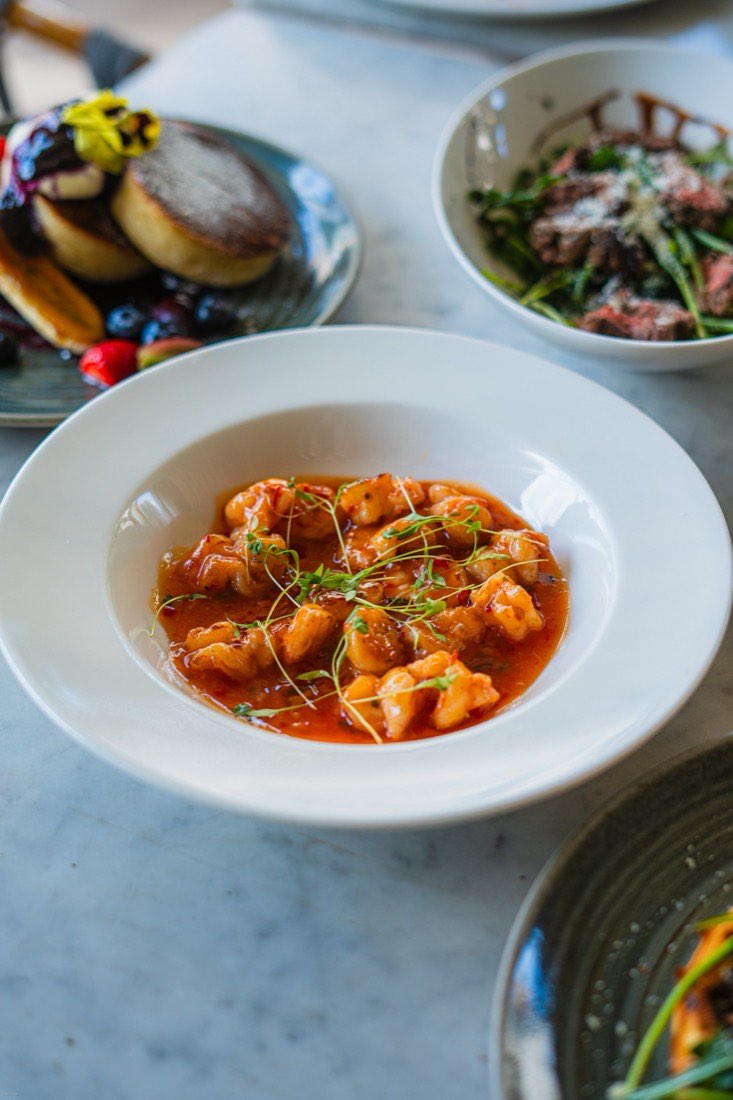 Overhead shot of chili prawns and a full table spread at Papparoti