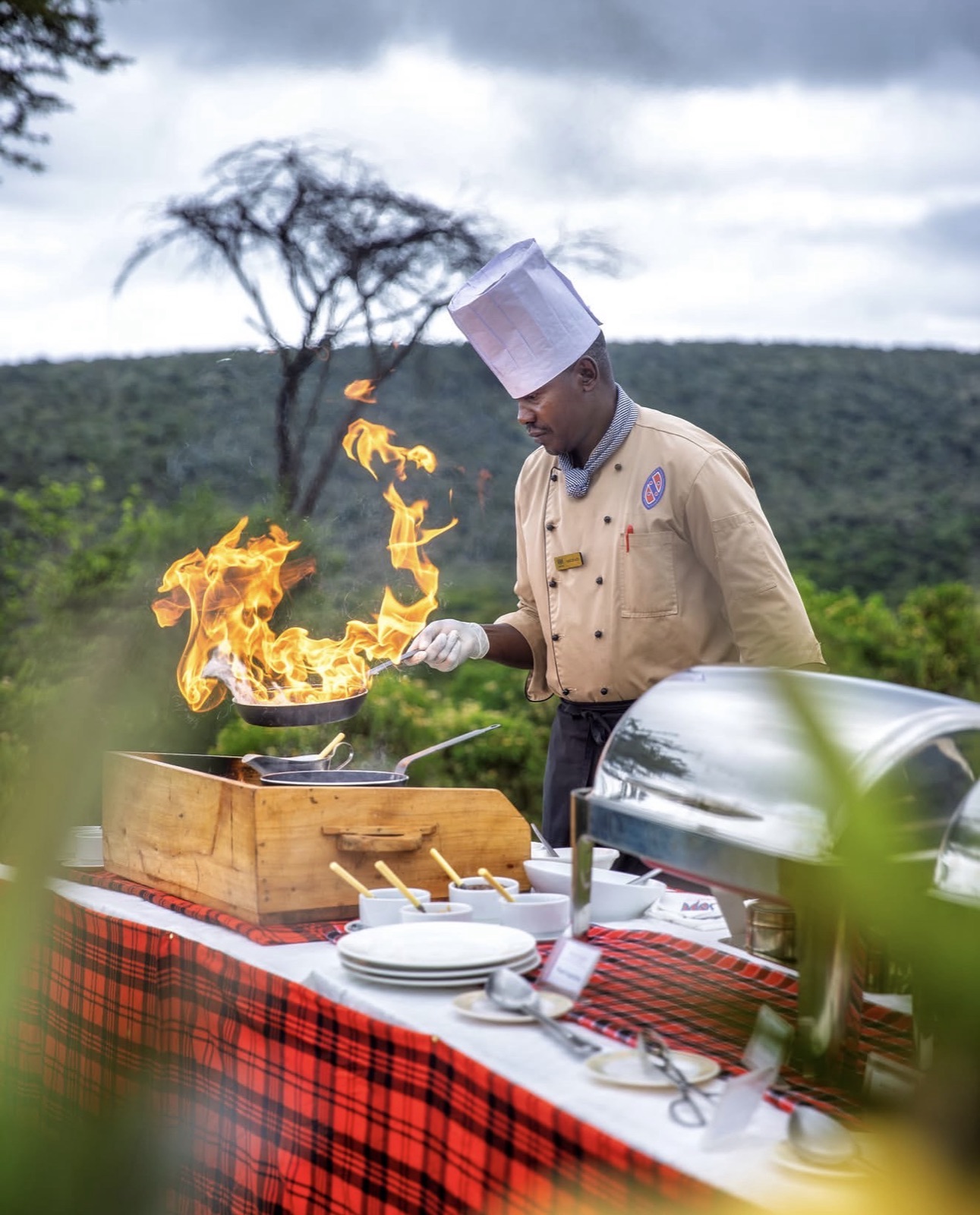 Chef flambéing at an outdoor grill station