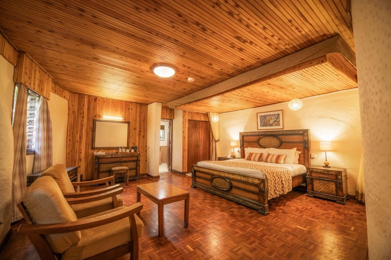 Timber-ceilinged guest room with a sitting area